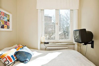 Телевизор в маленькой спальни можно повесить на кронштейне
