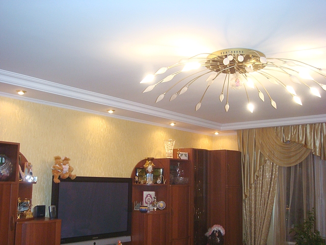 Если в гостиной используется большая люстра, то лучше чтобы она была габаритной в ширину и близко крепилась к потолку