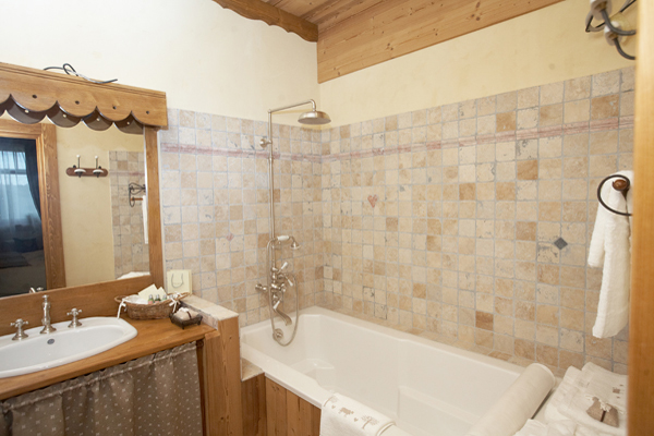 Стіни у ванній в стилі прованс викладені мармуром і оброблені декоративною штукатуркою